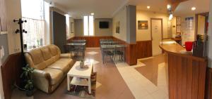 een lobby van een ziekenhuis met een bank en tafels bij Hotel des Bains in Maisons-Alfort