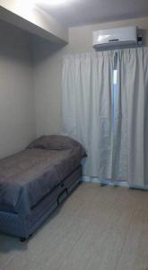 a bedroom with a bed and a window with curtains at ALQUILER TEMPORARIO VILLA UNION in Villa Unión