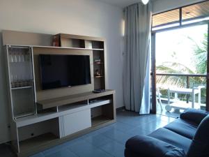 uma sala de estar com televisão e um sofá azul em Apto confortável de 3 quartos-Cabo Frio em Cabo Frio