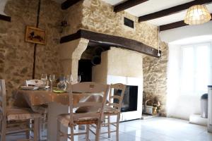 uma cozinha com uma mesa com cadeiras e uma lareira em Gîte **** "le refuge des fées" em Saint-Julien-du-Gua