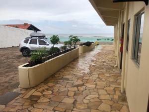 薩利諾波利斯的住宿－Hotel Concha do Mar，停在海边的建筑物旁的汽车