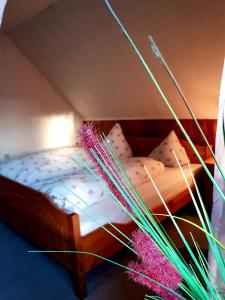 a bedroom with a wooden bed with pink sheets at Hotel & Restaurant Gulfhof in Emden