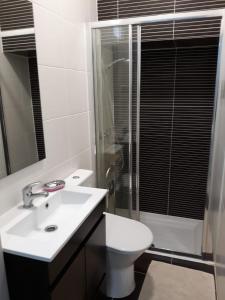 a bathroom with a toilet and a sink and a shower at Chainha's Dream Apartment in Sesimbra