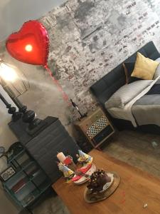 エゲルにあるMini Loft Apartmanの赤いハートバルーンとベッドが備わる客室です。