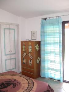 a bedroom with a bed and a dresser and a window at Stella Marina in Valledoria