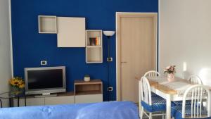 a blue room with a table and a television at La Casa di Ermelinda in Sapri