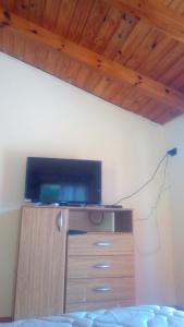 1 dormitorio con TV en la parte superior de un tocador en EL TUKI en Villa Traful