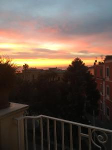 ナポリにあるSuite Klimt P.zza Amedeoの建物のバルコニーからの夕日