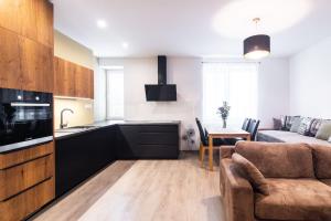 eine Küche und ein Wohnzimmer mit einem Sofa und einem Tisch in der Unterkunft Newly renovated, Full Equipped and Quiet Apartment in Trnava