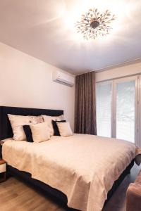 - une chambre avec un grand lit et un lustre dans l'établissement Newly renovated, Full Equipped and Quiet Apartment, à Trnava
