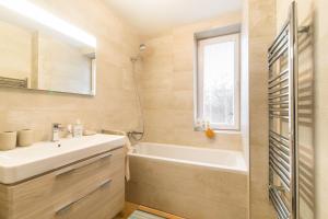 a bathroom with a sink and a tub and a window at Newly renovated, Full Equipped and Quiet Apartment in Trnava