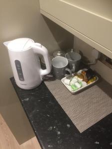a coffee pot sitting on a counter with a plate of food at Private en-suite guestroom Ruthin in Ruthin