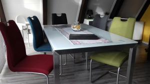 einen Esstisch mit Stühlen und eine Glasschüssel darauf in der Unterkunft Nurdachhaus 128 Ferienpark Fedderwardersiel in Butjadingen