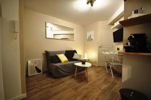 a living room with a couch and a table at Studio cosy en hypercentre, quartier St Etienne in Toulouse