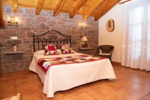 a bedroom with a bed and a stone wall at Turisme Rural Lo Pallé de Cal Bosch in Llagunes