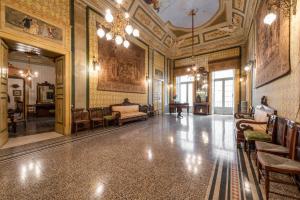 ジョヴィナッツォにあるPalazzo Framarino dei Malatestaのベッドとシャンデリアが備わる広い客室です。