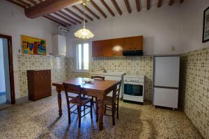 a kitchen with a wooden table and chairs in it at Ospiti del Borgo - Casa del Giusti in Lorenzana