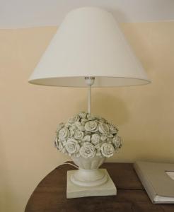 a white lamp with a bouquet of flowers on a table at Domaine Le Castelet in Castres