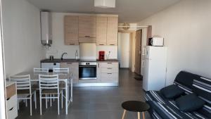 uma cozinha com uma mesa e cadeiras e um frigorífico em OSARI - MORIANI plage em Moriani Plage