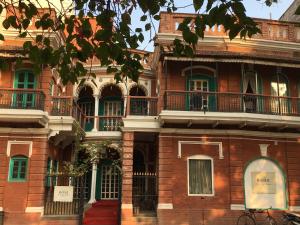 un edificio de ladrillo rojo con balcones. en Rose Heritage Home en Varanasi