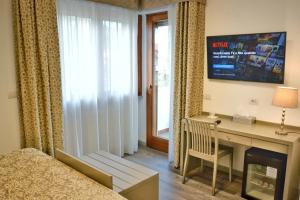 a bedroom with a television and a bed at Hotel Tiffany in Marina di Massa