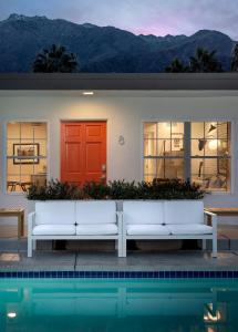 a house with a red door next to a pool at the Weekend Palm Springs in Palm Springs