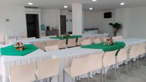 a room with tables and chairs with green tablecloths at Hotel Barbacoa Apartadó in Apartadó