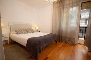 a white bedroom with a bed and a window at Los Respigos Ampuero in Ampuero