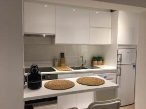 a kitchen with white cabinets and white counters at Apartamento Vilamoura Marina in Vilamoura