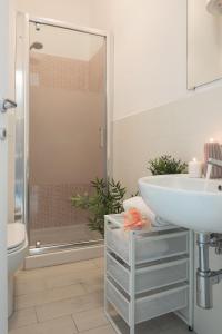 y baño blanco con lavabo y ducha. en Oki Doki Studios, en Milán