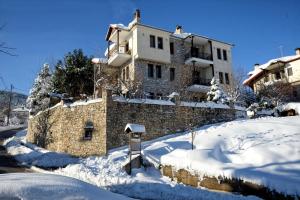 una casa en la nieve con patio cubierto de nieve en Anthemion, en Neochori