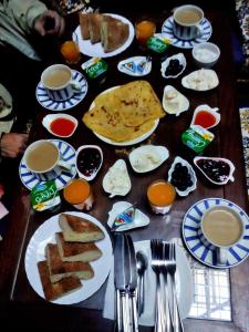 une table avec des assiettes de nourriture et des tasses de café dans l'établissement Moroccan Dream Hostel, à Fès