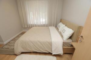 Cette petite chambre comprend un lit avec des draps et des oreillers blancs. dans l'établissement ★ The Cozy Little Apartment ★, à Shkodër