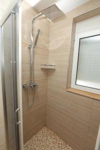 La salle de bains est pourvue d'une douche avec une porte en verre. dans l'établissement ★ The Cozy Little Apartment ★, à Shkodër