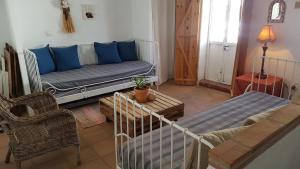 a living room with a couch with blue pillows at Cortes de la Frontera Townhouse in Cortes de la Frontera