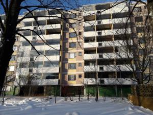 ヘルシンキにある2 room apartment in Pasilaの雪の目の前のアパートメント