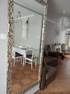 a mirror in a living room with a table and a couch at Borókahaus in Tata