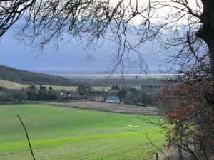 a view of a green field with the ocean in the background at The Barn, Wolds Way Holiday Cottages, 2 bed ground floor in Cottingham