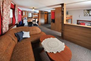 a living room with a brown couch and a table at Penzión Lampáš in Poprad