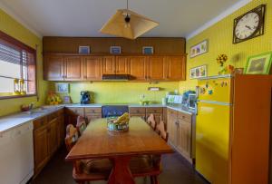 uma cozinha com uma mesa e um frigorífico amarelo em River-side Villa em Vila Nova de Cerveira