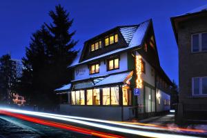 a building with a sign on the side of it at night at Penzión Lampáš in Poprad