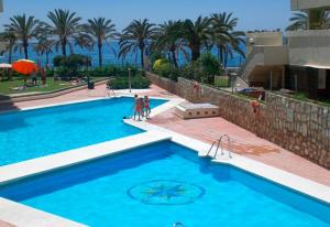 una piscina con due persone in piedi accanto di Mariana & Sirus´ Home a Marbella