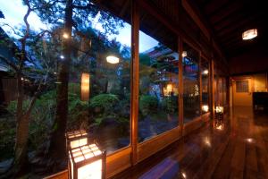 una camera con una grande finestra che si affaccia su un giardino di Ryokan Sennari (13 years or older) a Beppu