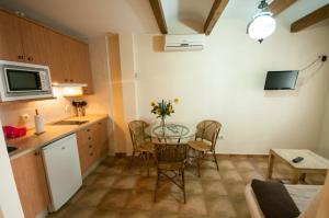 cocina pequeña con mesa, sillas y microondas en Apartamentos Turísticos Rincón de la Magdalena, en Plasencia