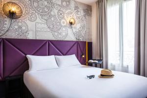 クリシーにあるibis Styles Paris Mairie De Clichyのベッドルーム1室(大型ベッド1台、帽子付)