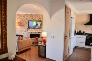 una sala de estar con un arco que conduce a una sala de estar en Jardins do Golf, Val do Lobo, en Almancil