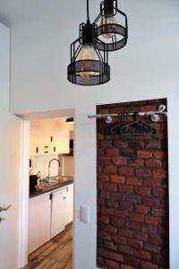 a brick wall in a kitchen with a chandelier at Urban by BestChoice - FREE Parking - Self Check-in in Graz