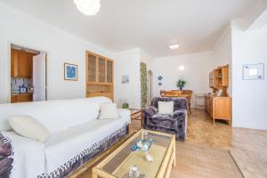 un salon avec un canapé blanc et une table dans l'établissement Av. 1º de Maio, à Costa da Caparica