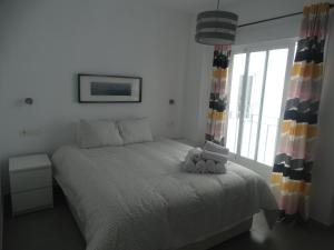 sypialnia z łóżkiem, na którym leżą dwa misie w obiekcie Málaga Apartamentos - Jinetes, 10 w Maladze