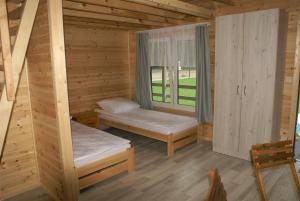 a room with two bunk beds and a window at DIUNA Domki Letniskowe in Pobierowo